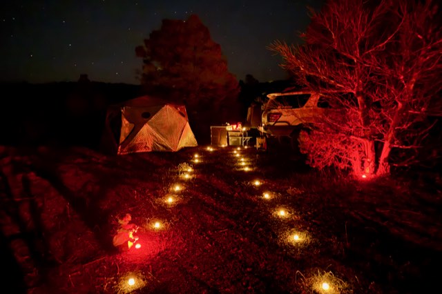 Yellow Jeep and decorated camp lit red